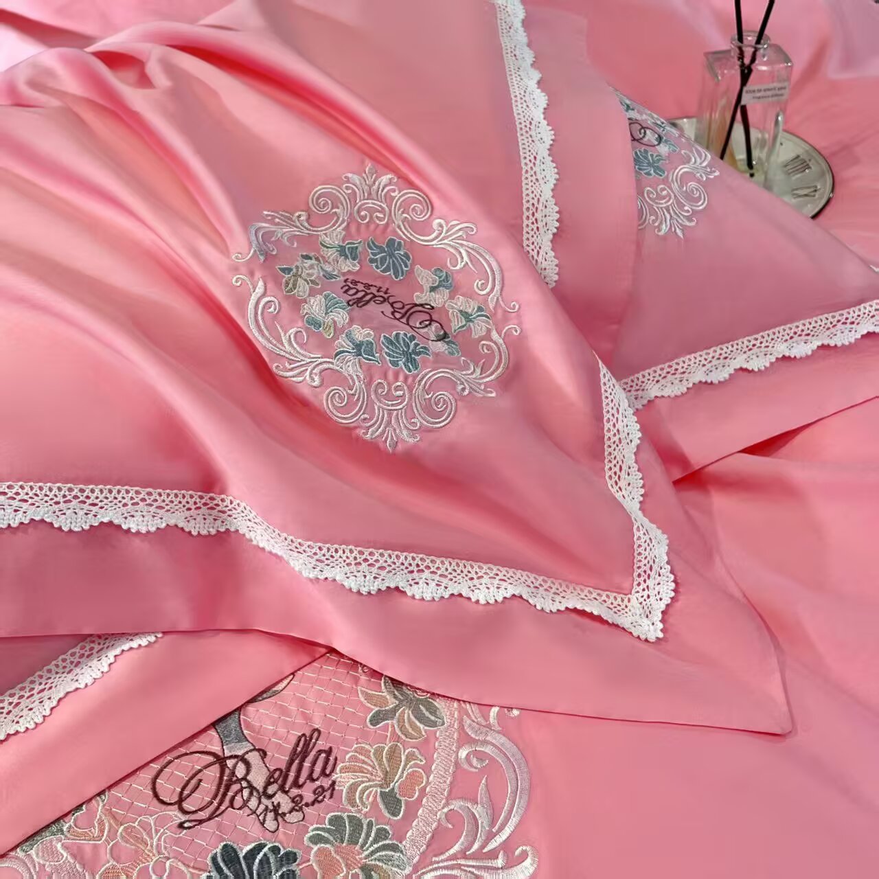 Lace border and embroidery on pink satin bedding