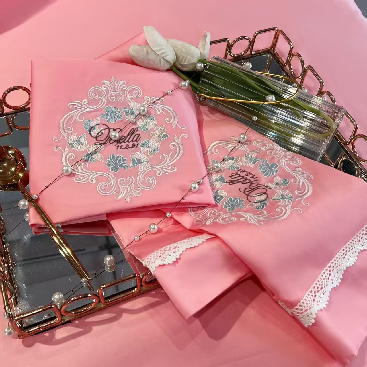 Decorative embroidery motif detail on pink bedding